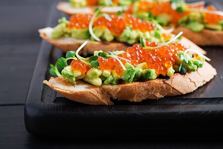 Sandwiches with salmon red caviar and salsa with avocado. Sandwich for lunch. Delicious food.