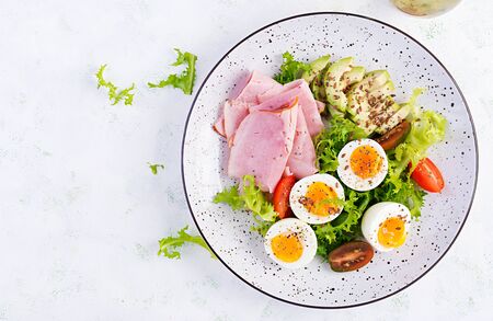 Ketogenic/paleo diet. Boiled eggs, ham, avocado and fresh salad.  Keto breakfast. Brunch.  Top view,...
