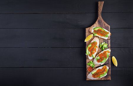 Sandwiches with salmon red caviar with sliced avocado. Sandwich for lunch. Premium food. Top view, overheadの写真素材