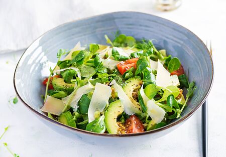 Healthy salad of fresh vegetables - tomatoes, avocado, corn salad, pea sprouts and chia seeds in bowl. Paleo diet menu.の写真素材