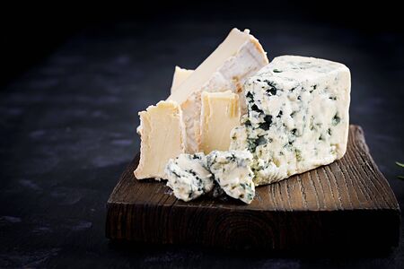 Cheese on wooden boards. Camembert and dorblu on wooden background. Dairy products