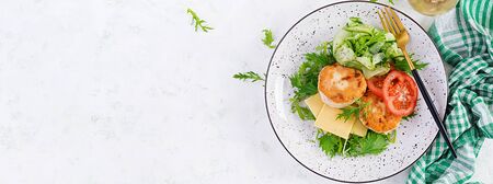 Ketogenic lunch. Chicken burger with tomato, cucumber, cheese and arugula salad without bun. Chicken patties. Healthy food. Keto/paleo diet. Top view, overhead, bannerの写真素材