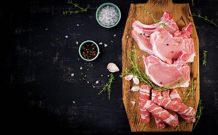 Raw pork steaks. Different types of raw pork meat and chopped sausages Ð¾n the dark table. Top view, overhead, copy spaceの写真素材