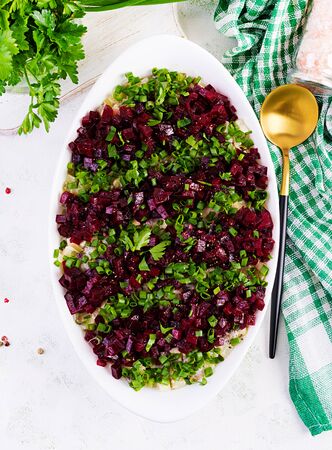 Kosher food, jewish salad. Herring,  pickled cucumber, beet, potato and apples salad on white  bowl.  Top view, copy space, flat layの写真素材
