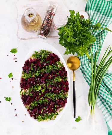 Kosher food, jewish salad. Herring,  pickled cucumber, beet, potato and apples salad on white  bowl.  Top view, copy space, flat layの写真素材