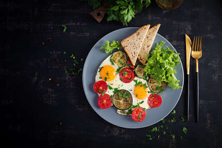 English breakfast - fried eggs, tomatoes and eggplant. American food. Top view, overhead, copy spaceの写真素材