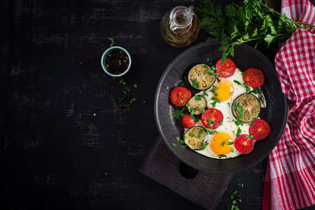 English breakfast - fried eggs, tomatoes and eggplant. American food. Top view, overhead, copy spaceの写真素材
