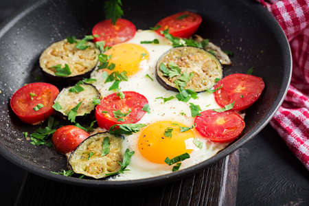 English breakfast - fried eggs, tomatoes and eggplant. American food.の写真素材