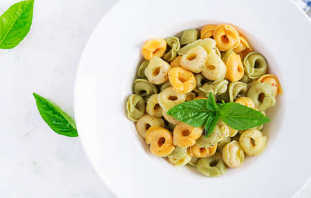 Italian ravioli pasta with spinach and ricotta in white plate. Italian tortellini pasta. Top view, flat lay, overheadの写真素材