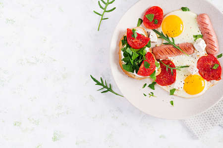 English breakfast - fried eggs, sausages, tomatoes and feta cheese. American food. Top view, overhead, copy spaceの写真素材