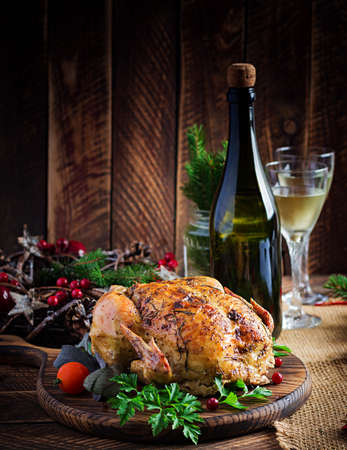 Baked turkey or chicken. The Christmas table is served with a turkey, decorated with bright tinsel. Fried chicken, table setting. Christmas dinner.の写真素材