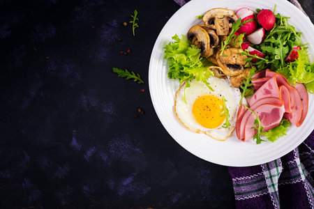 English breakfast - fried eggs, ham, fried mushrooms, radish and arugula. ketogenic, keto food. Top view, overhead, copy spacの写真素材