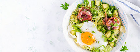 Ketogenic, paleo diet. Fried egg, prosciutto, avocado and fresh salad. Keto breakfast. Brunch. Top view, overhead, bannerの写真素材