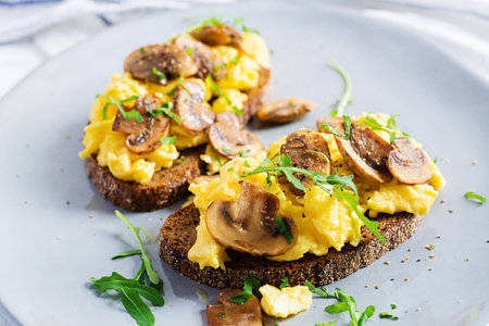 Scrambled eggs and fried mushrooms on bread. Homemade breakfast or brunch meal - scrambled eggs and mushrooms sandwiches.の写真素材