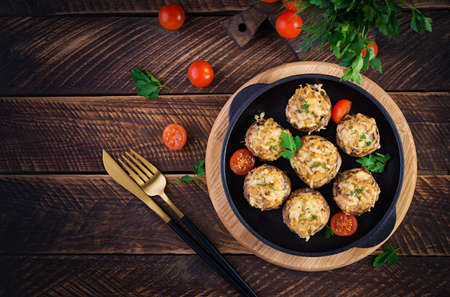 Baked mushrooms stuffed with chicken minced meat, cheese and herbs on a wooden background. Top view, above, copy spaceの写真素材