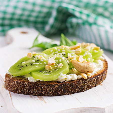 Vegetarian breakfast. Sandwich cream cheese, kiwi and nuts. Healthy breakfast or dinner.の写真素材