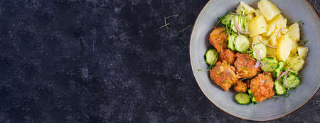 Steamed fish fillet with tomatoes sauce, boiled potatoes and fresh cucumber salad. Diet meal. Lenten food. Top view, aboveの写真素材