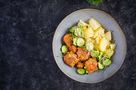 Steamed fish fillet with tomatoes sauce, boiled potatoes and fresh cucumber salad. Diet meal. Lenten food. Top view, aboveの写真素材