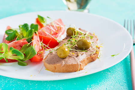 Fresh homemade chicken liver pate on bread and tomatoes salad. Breakfast.の写真素材