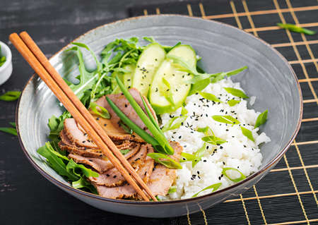 Homemade baked sliced beef and rice bowl with salad. Diet menu.の写真素材
