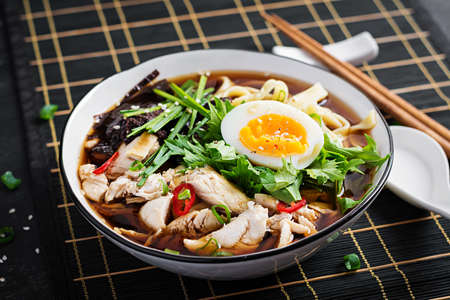 Miso soup. Japanese ramen soup with chicken, egg, nori and nipposinica on dark background.