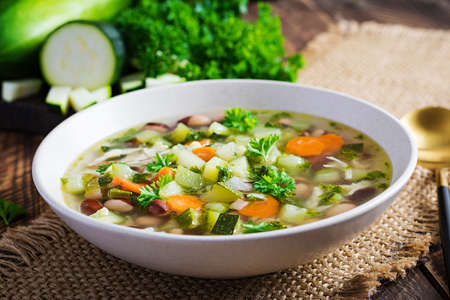 Chicken fillet vegetable soup in bowl on wooden rustic table.の写真素材