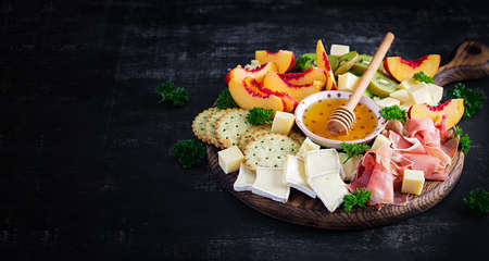 Italian antipasto catering platter with prosciutto, cheese and fruit on a dark background. Top view, overheadの写真素材
