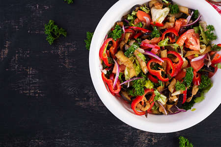 Salad baked eggplant and fresh tomatoes. Warm eggplant salad. Top view, flat layの写真素材
