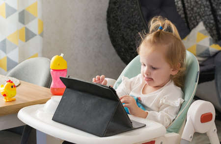 Little girl playing children's educational games on the tablet