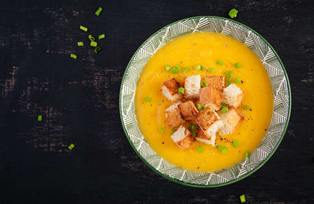 Creamy pumpkin puree soup with croutons, peppers and green onions. top view, aboveの写真素材