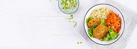 Orzo pasta, carrots and chicken burgers in a white bowl. Risoni pasta. Lunch. Top view, above, copy...
