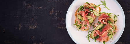 breakfast or brunch. Open sandwich with prosciutto or jamon on white plate. Mediterranean appetiser. Top view, overheadの写真素材