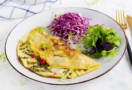 Ketogenic diet breakfast. Omelette with sorrel and fresh salad.