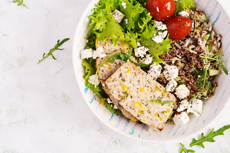 Healthy salad bowl with quinoa, tomatoes, chicken meatloaf and feta cheese on bowl. Top view, flat lay. food and health.の写真素材