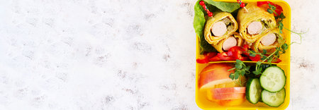 School lunch box with sausage roll in omelette with lavash. Lunchbox. Keto lunch. Top view, flat layの写真素材