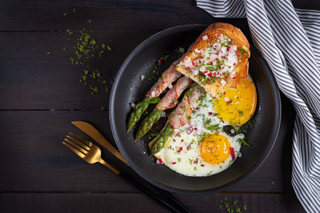 Keto breakfast. Fried eggs with asparagus in bacon and toast. Top view, flat layの写真素材