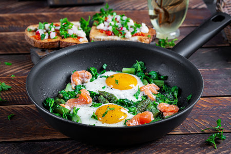 Keto breakfast. Fried eggs with asparagus, spinach and salmon.の写真素材