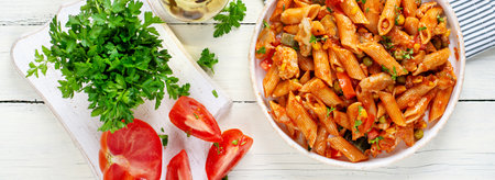 Classic Italian pasta penne arrabbiata with vegetables on white wooden table. Penne pasta with sauce arrabbiata. Top view, bannerの写真素材
