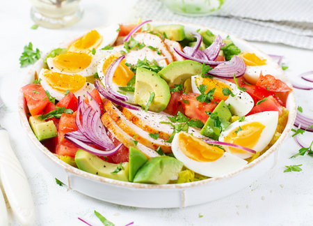Healthy cobb salad with chicken, avocado, tomato, red onions and eggs. American food.の写真素材