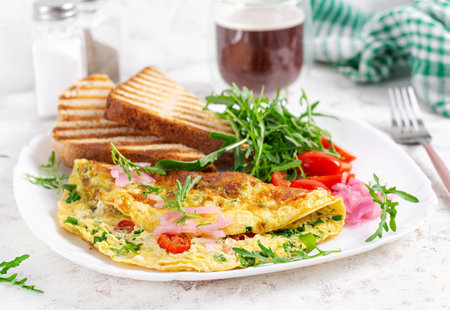 Healthy breakfast. Omelette with cheese, tomatoes and green herbs. Omelette, salad and toast. Keto, ketogenic lunch.の写真素材