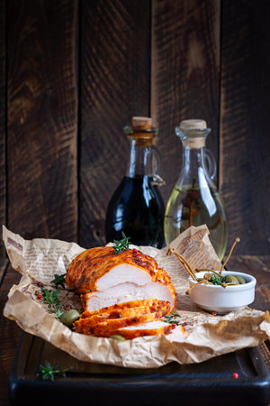 Chicken pastrami with red paprika and red pepper on wooden table. Meat delicacy. Diet food.の写真素材