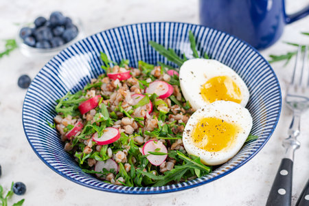 Healthy breakfast. Buckwheat porridge with boiled egg, radish and green herbs. Buckwheat tabbouleh.の写真素材