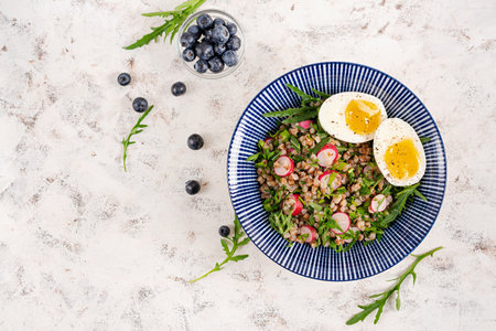 Healthy breakfast. Buckwheat porridge with boiled egg, radish and green herbs. Buckwheat tabbouleh. Top viewの写真素材