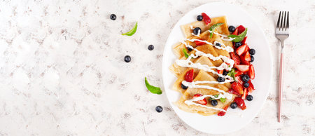 Pancakes with berries and sour cream. Healthy breakfast. Late breakfast. Crepes. Top view, bannerの写真素材