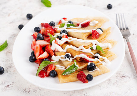 Pancakes with berries and sour cream. Healthy breakfast. Late breakfast. Crepesの写真素材