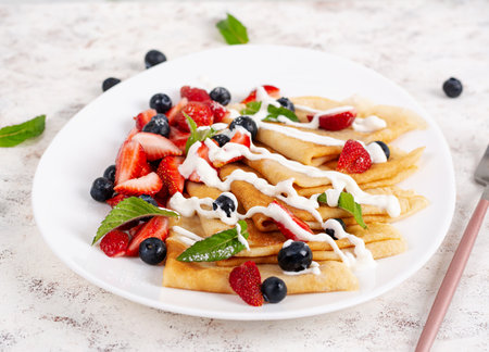 Pancakes with berries and sour cream. Healthy breakfast. Late breakfast. Crepesの写真素材