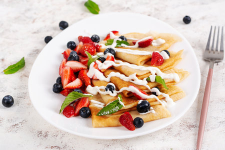 Pancakes with berries and sour cream. Healthy breakfast. Late breakfast. Crepesの写真素材