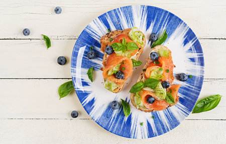 Breakfast. Open sandwiches with salted salmon, cucumber and blueberry. Seafood. Healthy food. Top view, flat layの写真素材