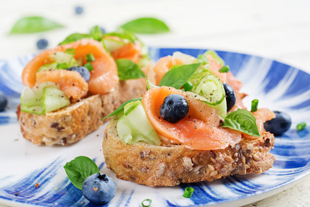 Breakfast. Open sandwiches with salted salmon, cucumber and blueberry. Seafood. Healthy food.の写真素材