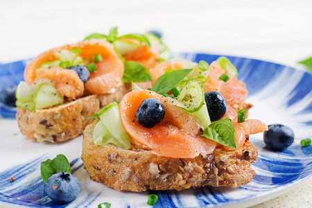 Breakfast. Open sandwiches with salted salmon, cucumber and blueberry. Seafood. Healthy food.の写真素材